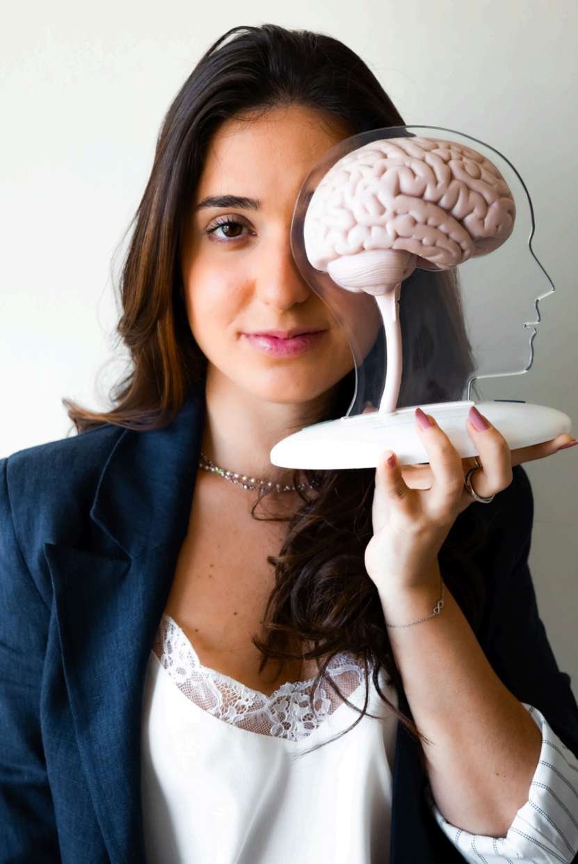Bruna Lisboa segurando um modelo que representa o cérebro